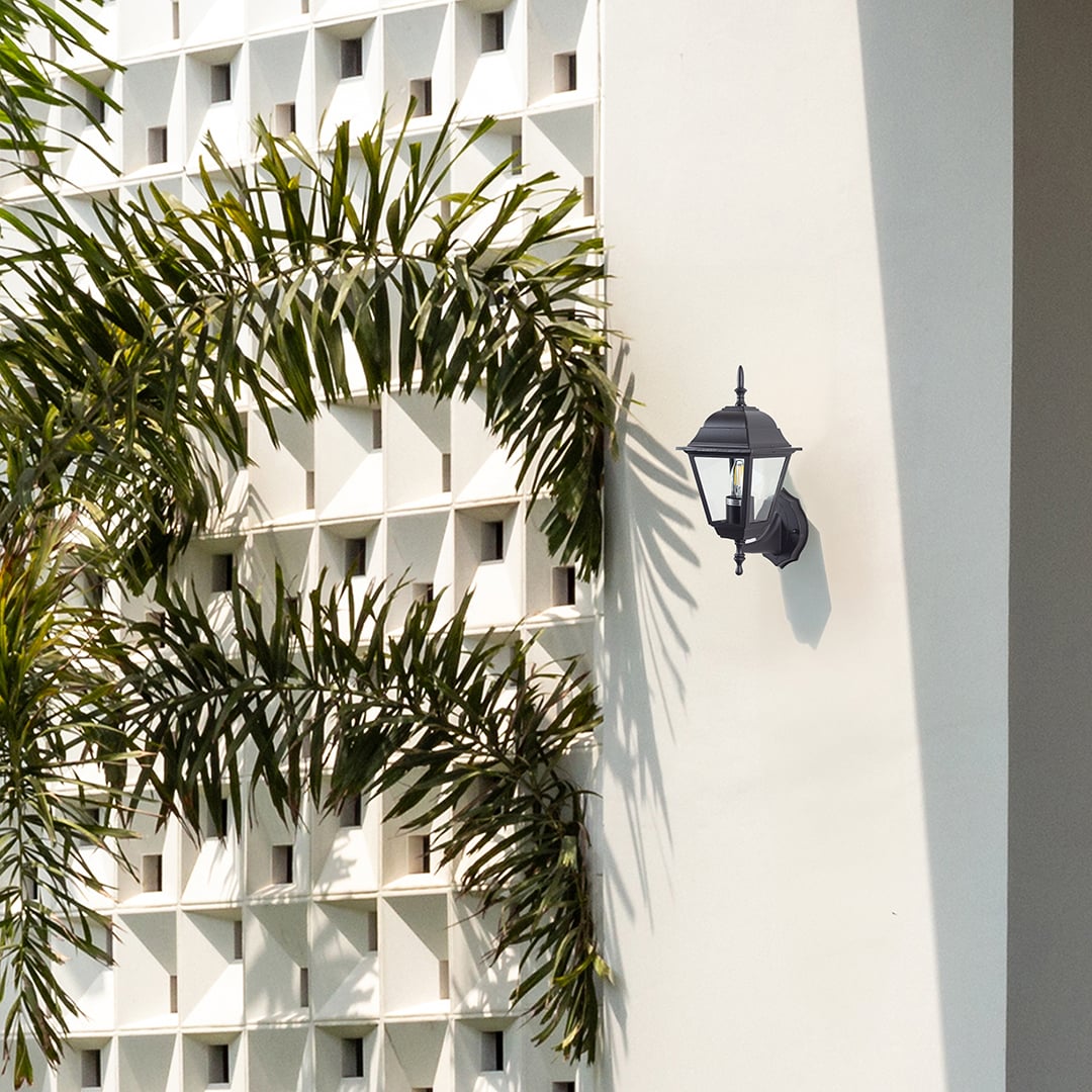Black metal outdoor wall light lifestyle image on modern exterior wall for stylish patio lighting decor.