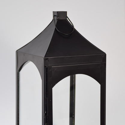 Closeup of black metal lantern with angular top and glass panels for luxury decor styling use.