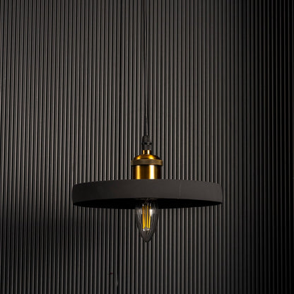 Black ring pendant light turned off emitting a soft warm glow highlighting its sleek circular silhouette against a dark backdrop.