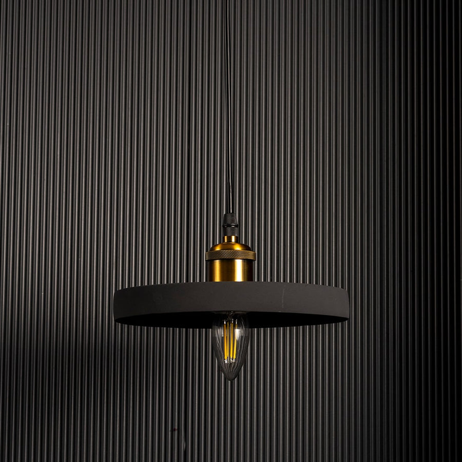 Black ring pendant light turned off emitting a soft warm glow highlighting its sleek circular silhouette against a dark backdrop.