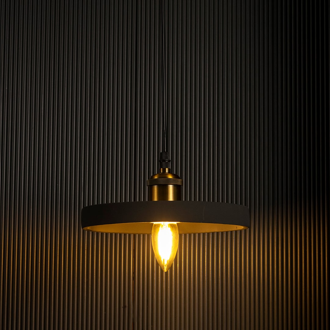 Black ring pendant light emitting a soft warm glow highlighting its sleek circular silhouette against a dark backdrop.