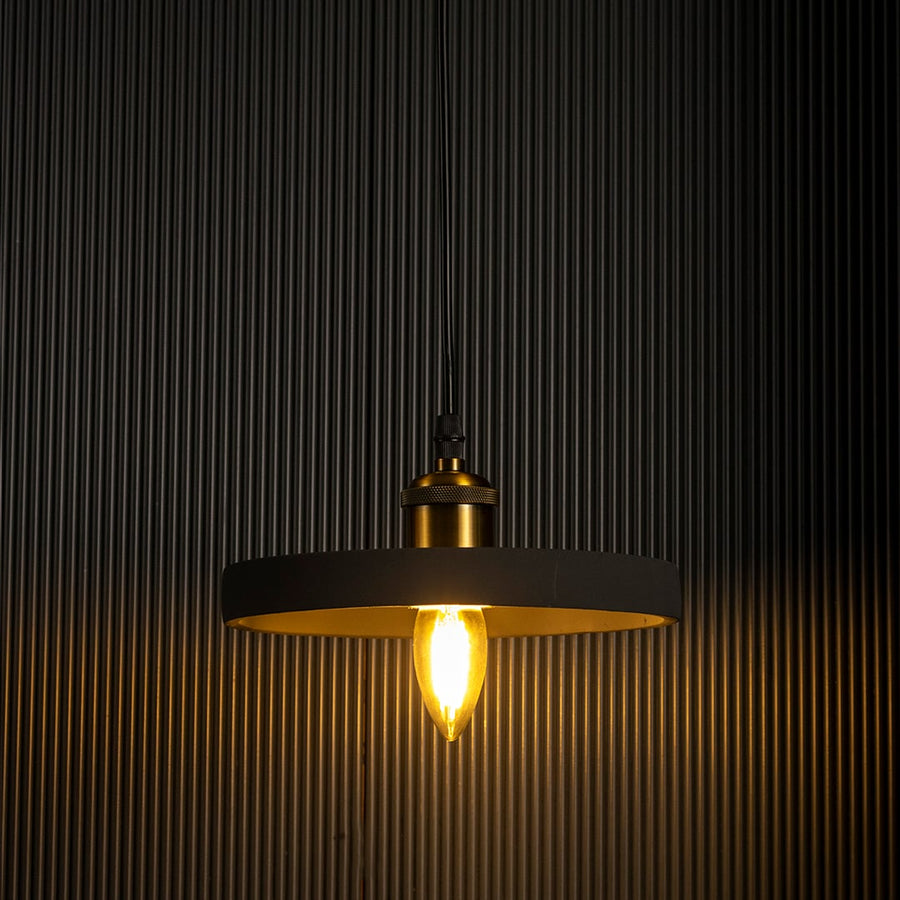 Black ring pendant light emitting a soft warm glow highlighting its sleek circular silhouette against a dark backdrop.