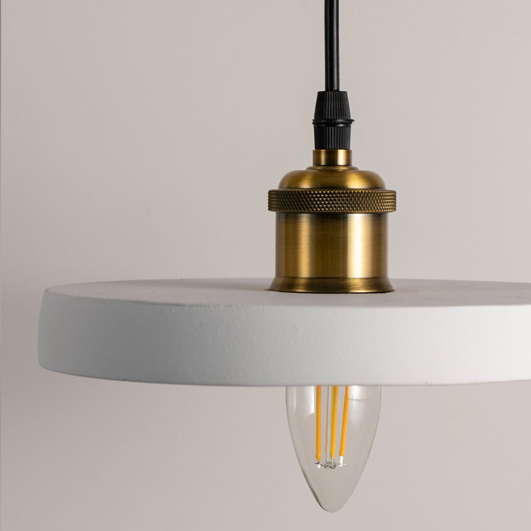White ring pendant light featuring a sleek circular design with brass holder and minimal modern silhouette with light off.
