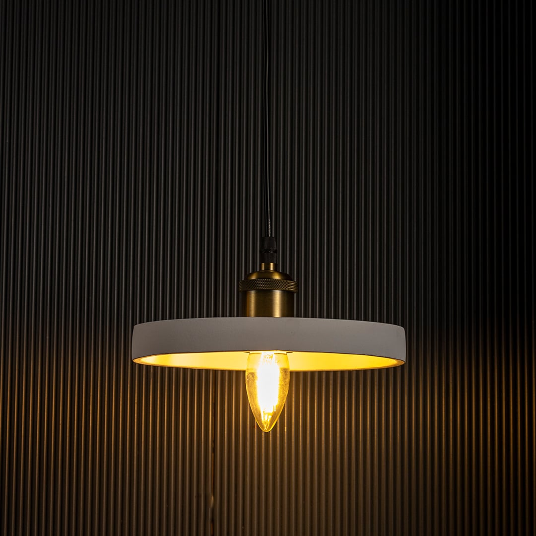 White ring pendant light radiating a soft golden light turned on with visible bulb and elegant circular frame on black background.