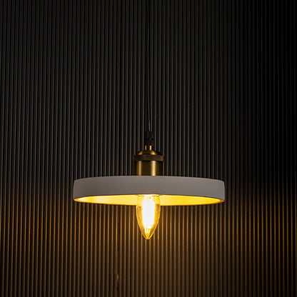 White ring pendant light radiating a soft golden light turned on with visible bulb and elegant circular frame on black background.