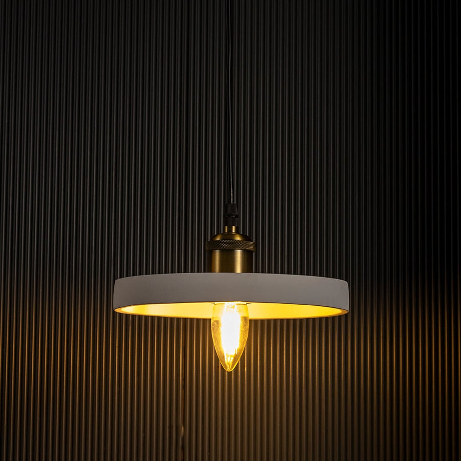White ring pendant light radiating a soft golden light turned on with visible bulb and elegant circular frame on black background.
