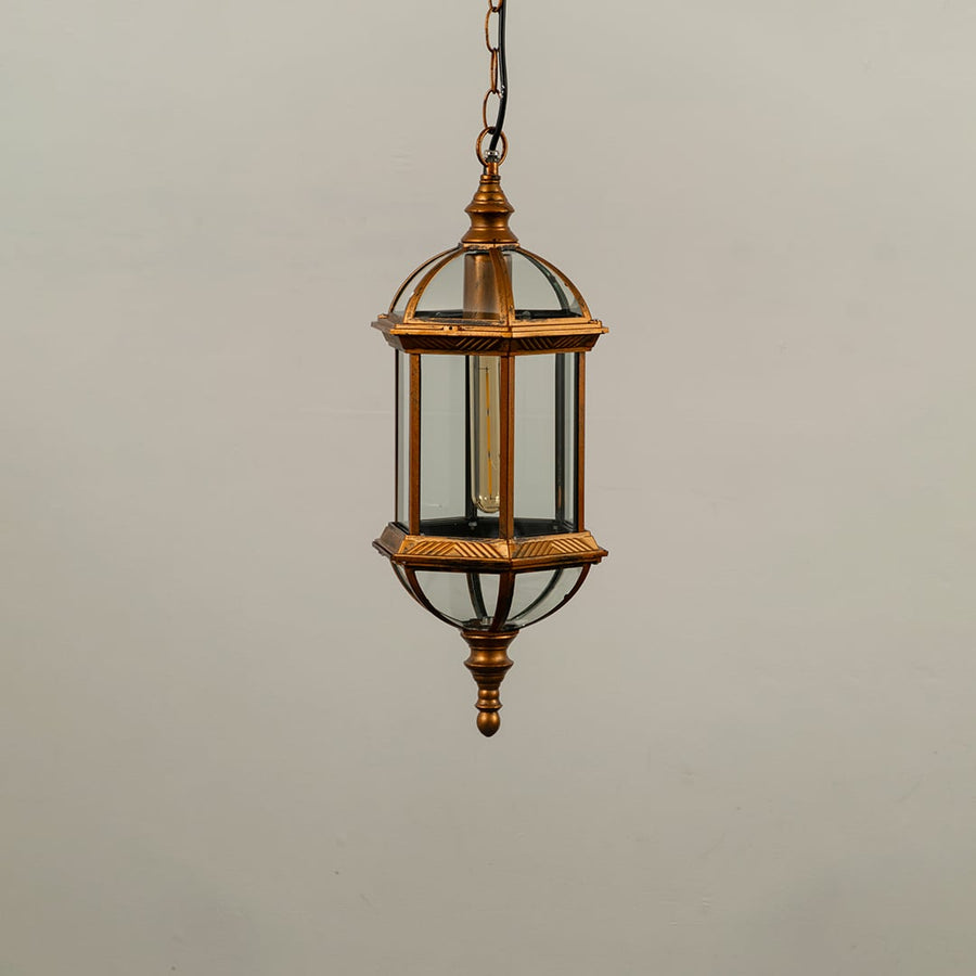 Black metal outdoor hanging light fixture with clear glass panels and elongated hexagonal shape isolated against a plain background.