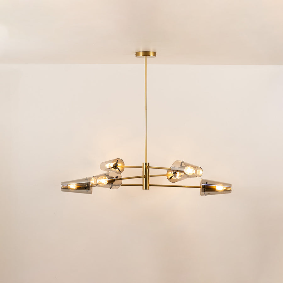 Clear glass chandelier with gold metal frame and illuminated bulbs creating warm contemporary ceiling lighting indoors.