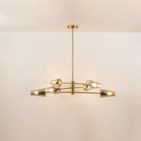 Clear glass chandelier with gold metal frame and illuminated bulbs creating warm contemporary ceiling lighting indoors.