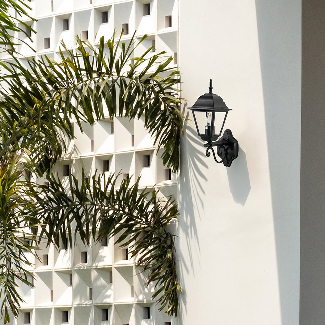 Black metal outdoor wall light lifestyle image on modern exterior wall for stylish patio lighting decor.