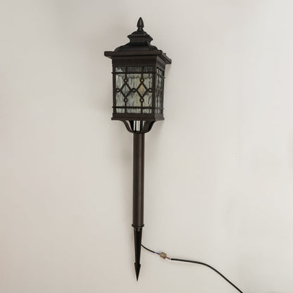 Black metal garden spike lantern with patterned glass shown with light off on a white background showcasing its detailed frame and tall spike base.