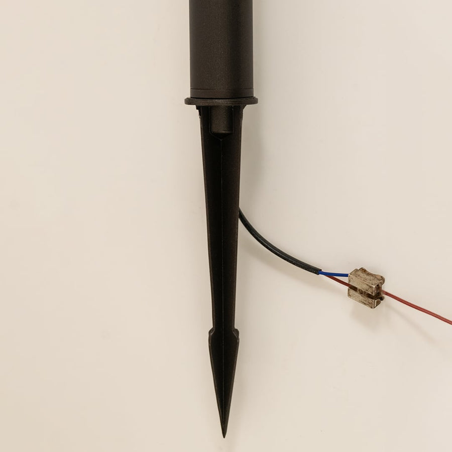 Detailed closeup of black outdoor spike light highlighting its textured glass design ornate frame and sturdy ground mounting spike.