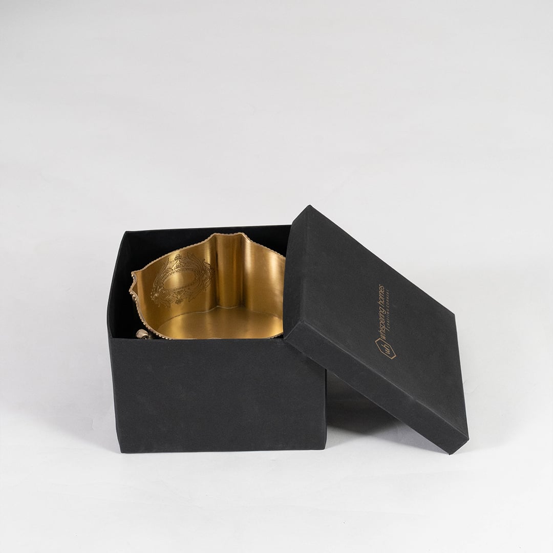 Ornate round brass planter with handles and etched floral design placed on white background for product display.
