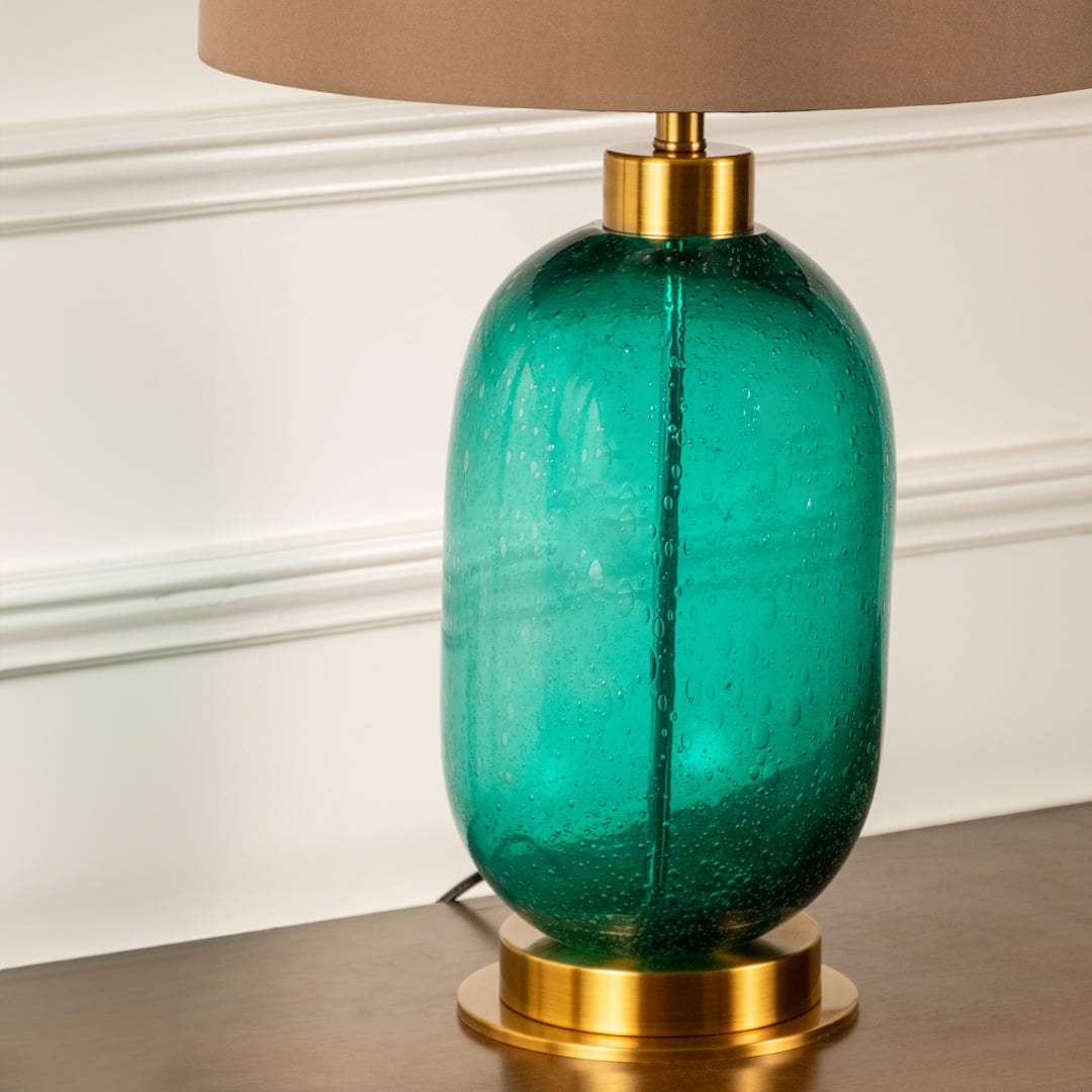 Teal glass table lamp with beige shade shown in close up view with light off for modern artistic décor styling.