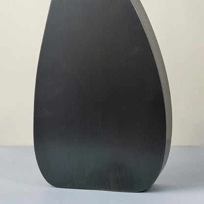 Detailed closeup of tall black wooden vase highlighting smooth matte surface for modern decor styling.