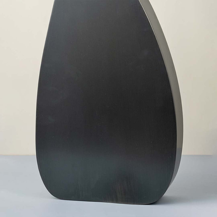 Detailed closeup of tall black wooden vase highlighting smooth matte surface for modern decor styling.