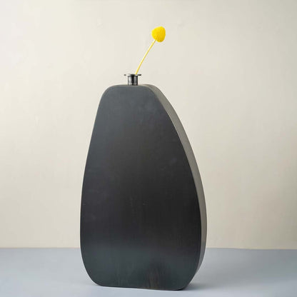 Tall black wooden vase with smooth matte finish styled with yellow flower for modern home and office decor.