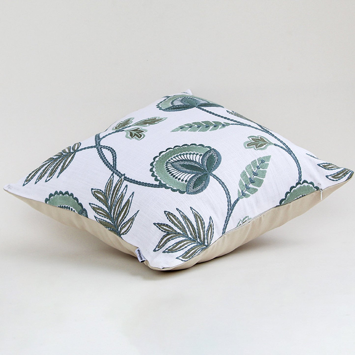 Alternate side view of the floral embroidered cushion showing its smooth edges and raised embroidery details.