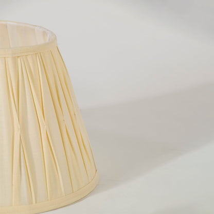 Closeup view of the cream pleated lampshade showing its detailed folds and fine craftsmanship for a clear and elegant product presentation.