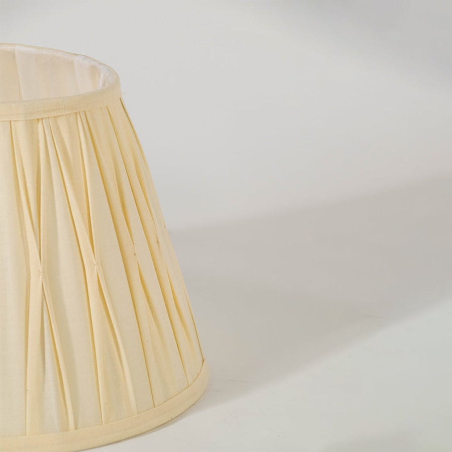 Closeup view of the cream pleated lampshade showing its detailed folds and fine craftsmanship for a clear and elegant product presentation.
