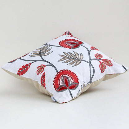 Soft cotton cushion cover with red floral embroidery displayed at an angle offering a lively nature inspired décor style with a breathable smooth and skin friendly material finish.