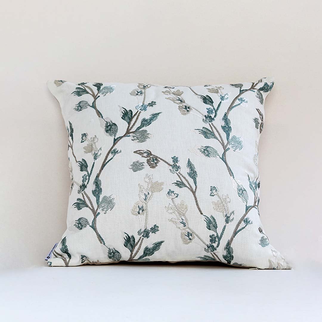 Soft white cotton cushion cover with teal botanical embroidery creating a fresh nature inspired décor accent with a breathable gentle and skin friendly material.