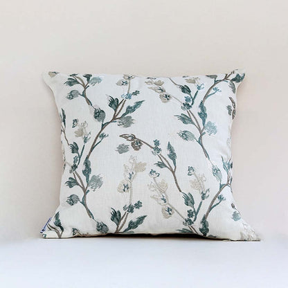 Soft white cotton cushion cover with teal botanical embroidery creating a fresh nature inspired décor accent with a breathable gentle and skin friendly material.