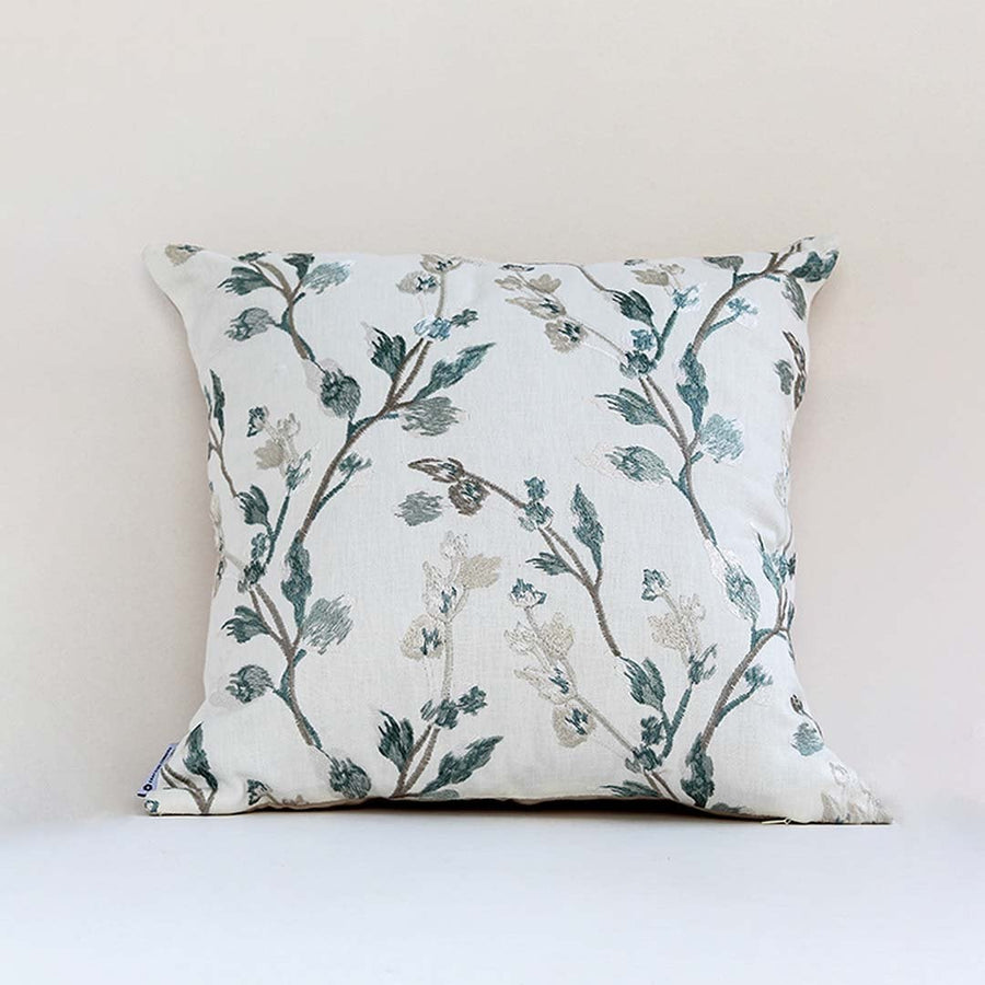 Soft white cotton cushion cover with teal botanical embroidery creating a fresh nature inspired décor accent with a breathable gentle and skin friendly material.