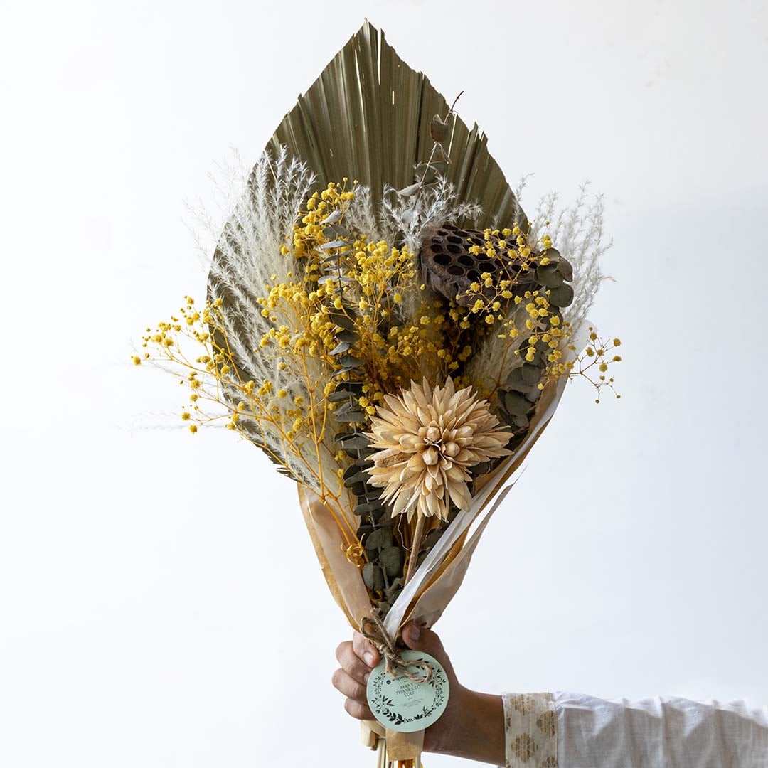 Preserved dried flower bouquet featuring yellow florals textured leaves and natural stems showing rich detailing and handcrafted finish.