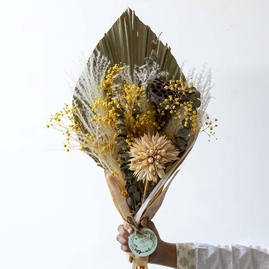 Preserved dried flower bouquet featuring yellow florals textured leaves and natural stems showing rich detailing and handcrafted finish.