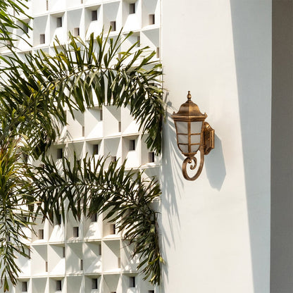 Elegant gold metal outdoor wall lantern light on illuminating a contemporary exterior facade with warm glow ideal for porch balcony patio and entryway Decor.