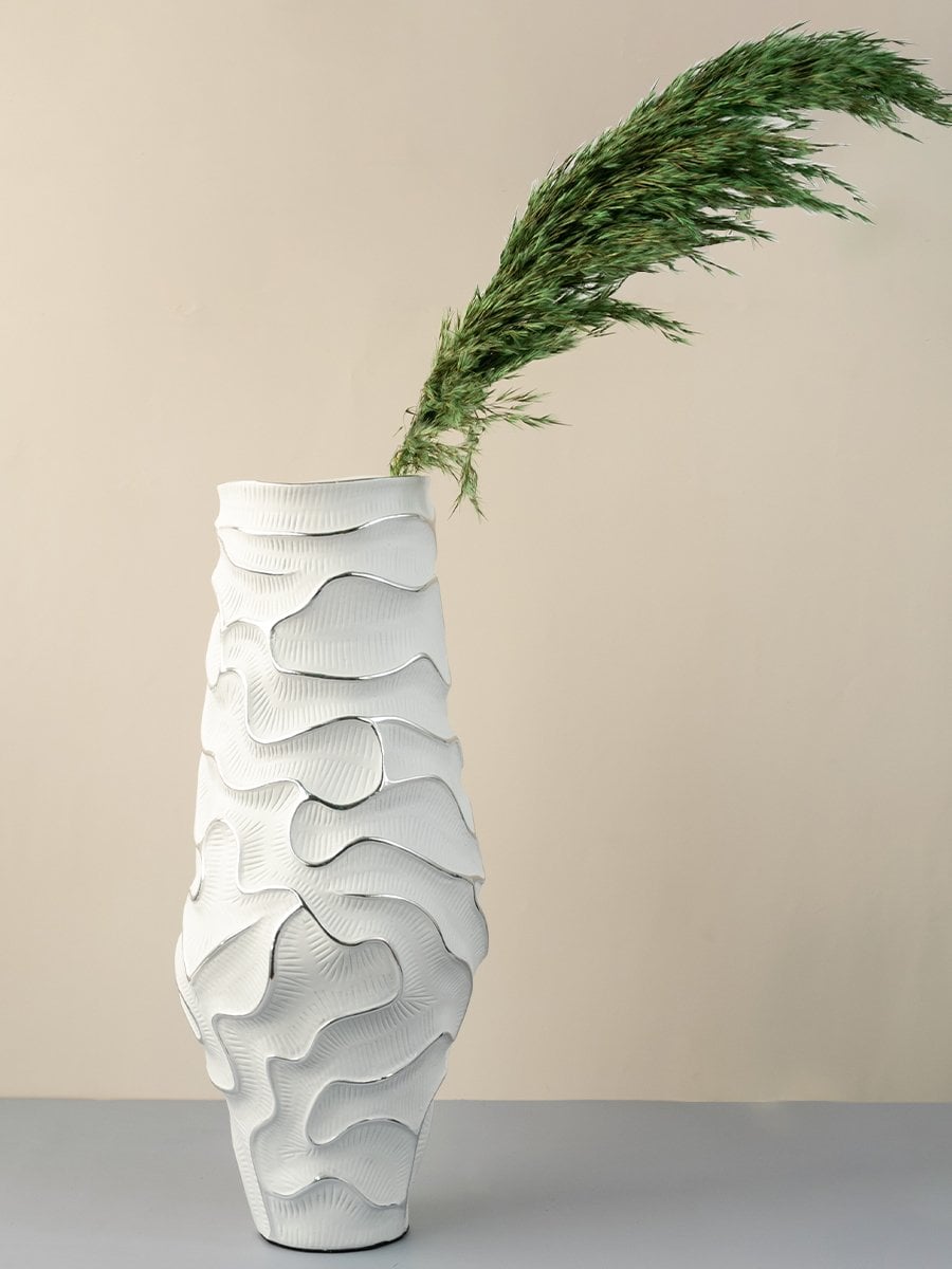 White ceramic vase with textured abstract design perfect for modern home decoration and interior styling.