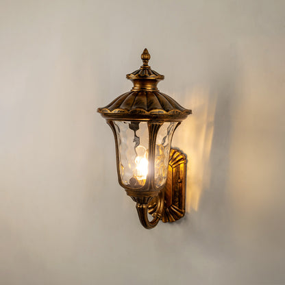 Vintage bronze outdoor wall light glowing on white wall for classic exterior entryway lighting decor.