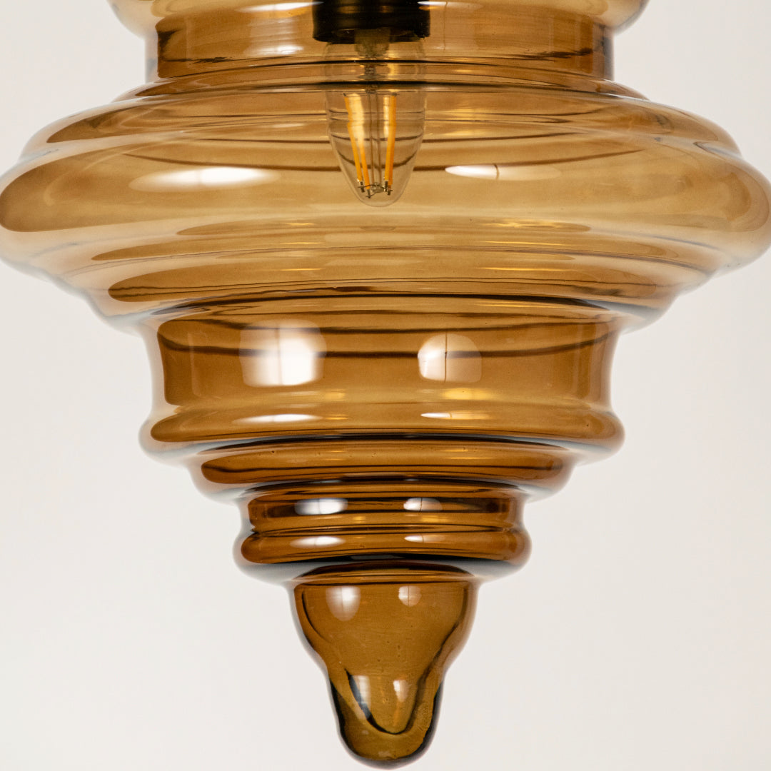 Amber ribbed glass pendant light showcasing textured layered glass craftsmanship and contemporary decorative lighting.