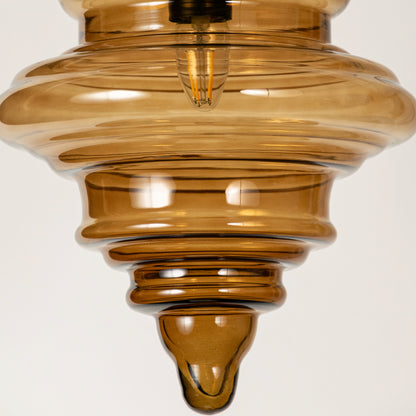 Amber ribbed glass pendant light showcasing textured layered glass craftsmanship and contemporary decorative lighting.