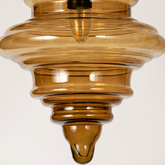 Amber ribbed glass pendant light showcasing textured layered glass craftsmanship and contemporary decorative lighting.
