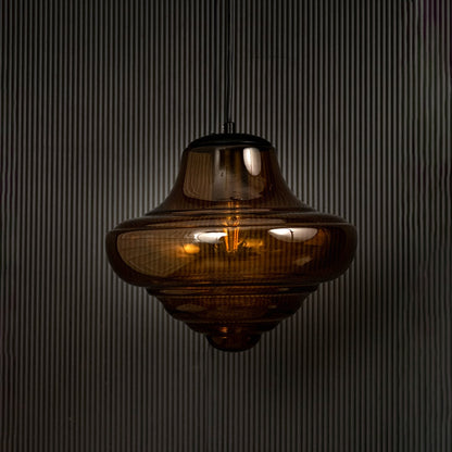 Amber glass pendant light displayed on dark background with light off emphasizing artistic design and premium glass finish.