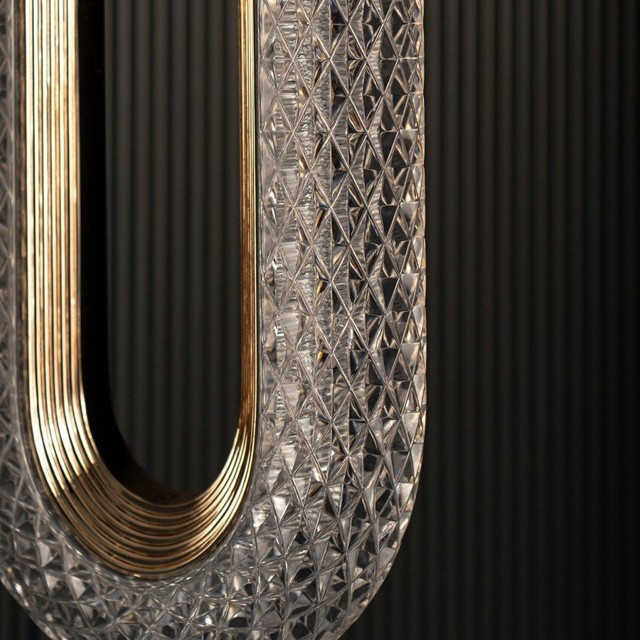 Closeup of oval crystal pendant light showcasing textured glass pattern and golden frame for modern home lighting