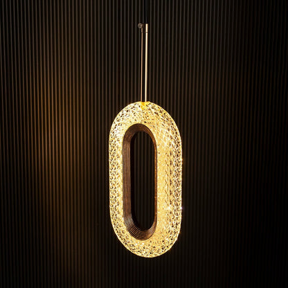 Crystal oval pendant lamp illuminated on black background highlighting golden detailing for a rich elegant look.