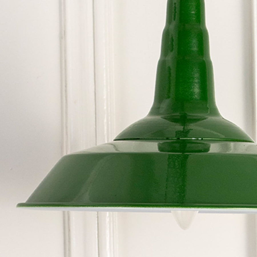 Classic green hanging pendant light with sleek design displayed on white wall background for elegant home decor.