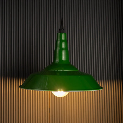 Green pendant lamp glowing softly on black background creating warm ambience for kitchen and dining spaces.
