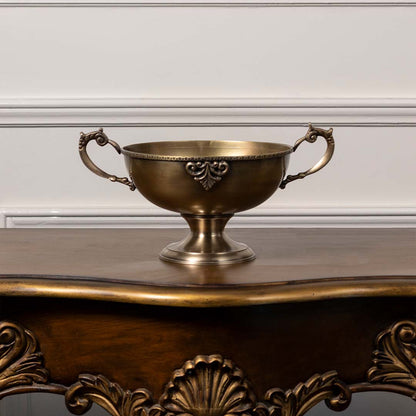 Antique brass pedestal bowl with ornate handles decorative centerpiece for dining table console and luxury home interiors.