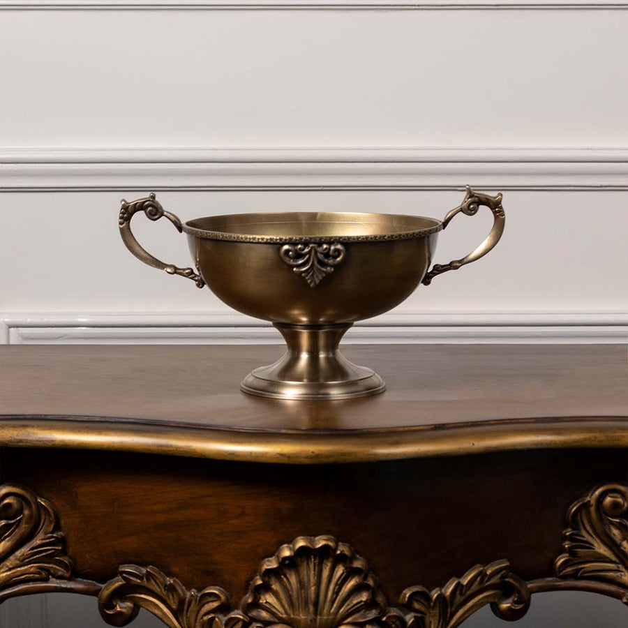 Antique brass pedestal bowl with ornate handles decorative centerpiece for dining table console and luxury home interiors.