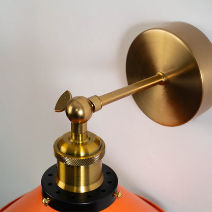 Closeup of orange cone wall light featuring brass holder and matte texture showing luxury craftsmanship and style.