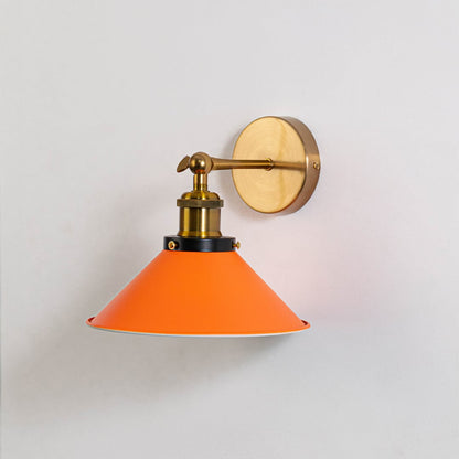 Orange wall lamp with brass mount turned off against white wall highlighting its sleek finish and industrial charm.