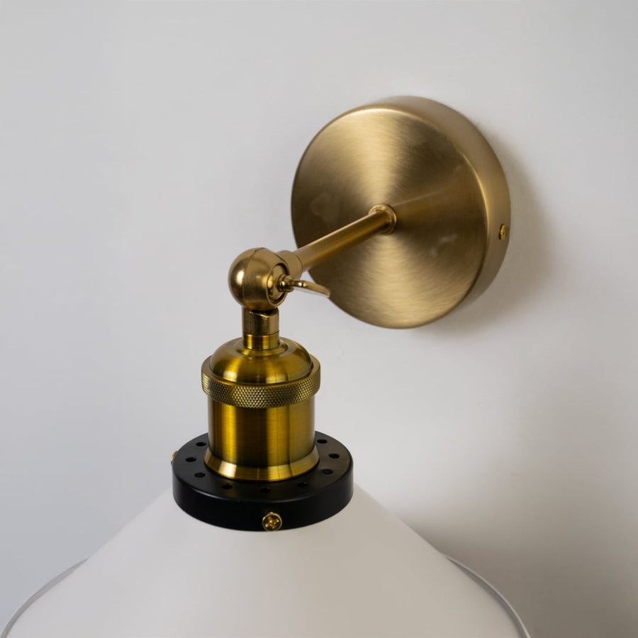 Detailed closeup of white metal cone wall light featuring brass holder and smooth matte texture for premium interiors.