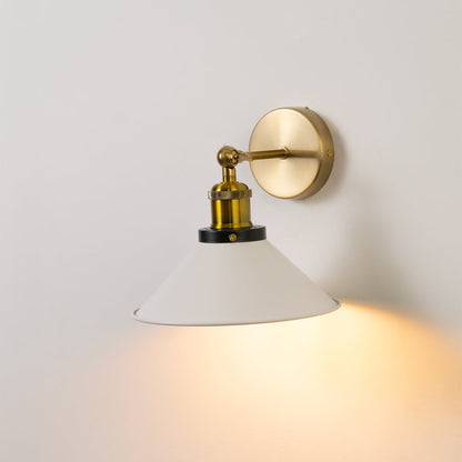 Modern white cone wall lamp with brass base glowing softly on white wall perfect for stylish interior lighting decor.