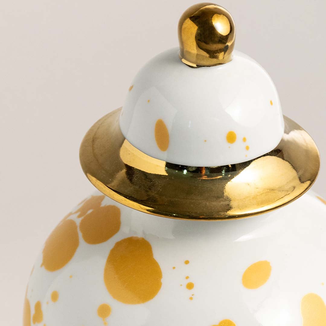 Close view of ceramic ginger jar with detailed gold splatter design and glossy finish enhancing premium home decor.