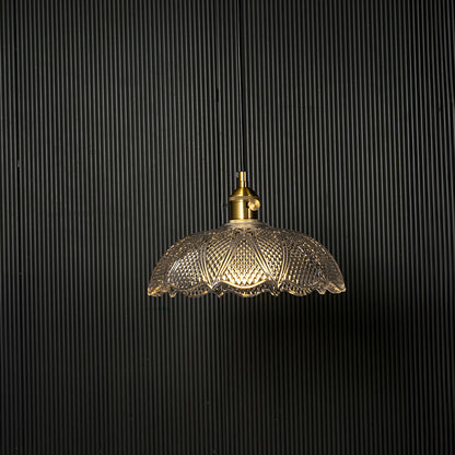 Clear patterned glass pendant light with gold metal accents designed for refined modern living spaces.