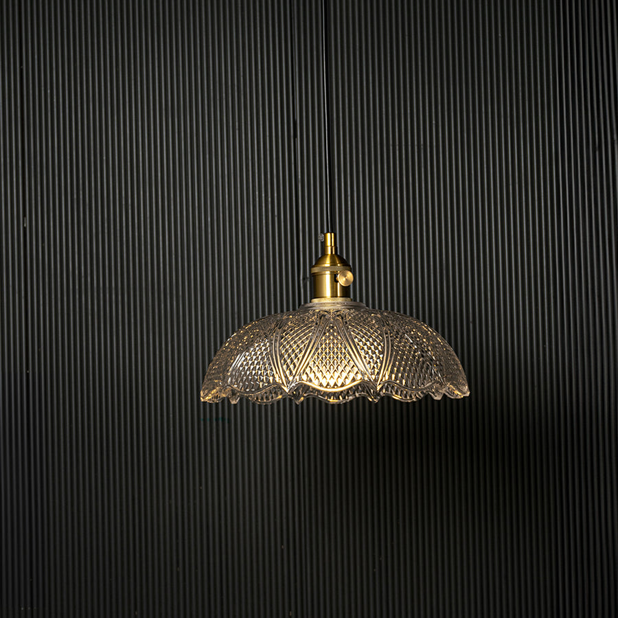 Clear patterned glass pendant light with gold metal accents designed for refined modern living spaces.